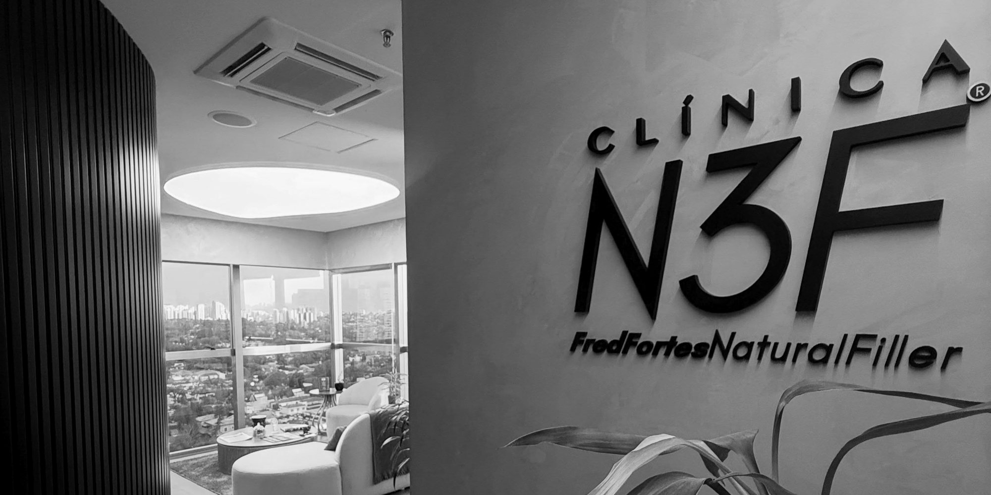 Entrada da Clínica N3F, com a marca na parede e a sala de espera ao fundo